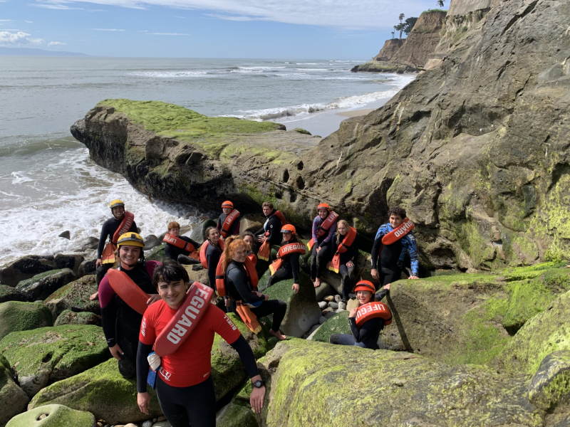 Lifeguard Staff posing on shoreline rocks